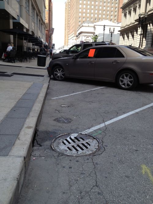 Warning sticker on Cadillac parked in no-parking area