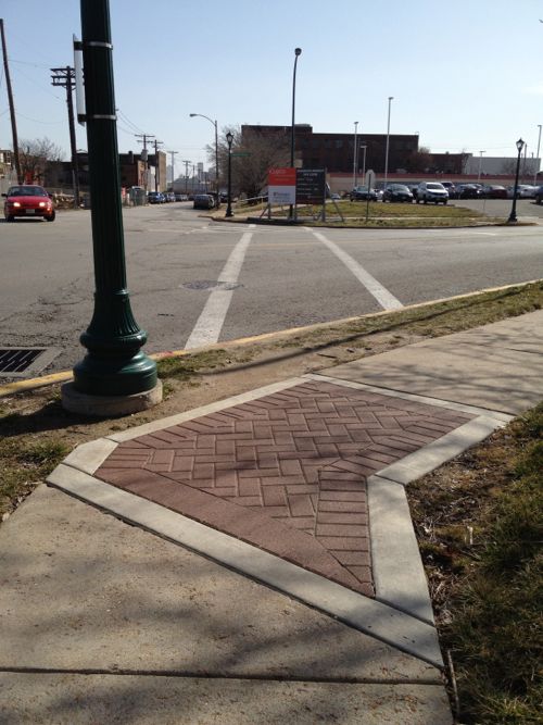This February 2012 photo looking East across Newstead at Duncan shows a crosswalk that's clearly not ADA-compliant -- no curb ramps! Decorative brick was a higher priority.