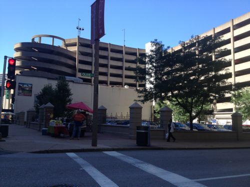 The corner of this block is a surface parking lot at 6th, the streetcar will turn onto 6th from Olive .