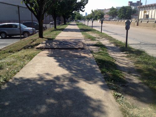 The worn grass shows many pedestrians avoid the obstacle in this sidewalk along the south side of Forest Park Ave, just west of Grand. 