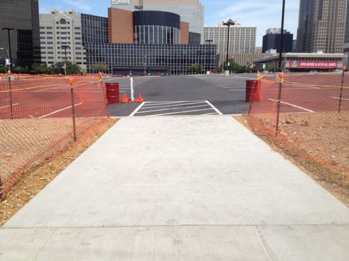 Newly poured walkway connecting new parking to the Clark St sidewalk has a curb instead of a ram.