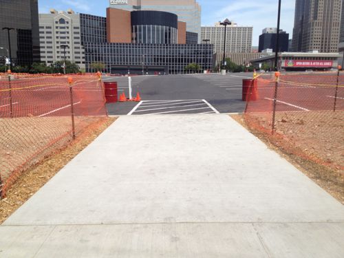 Newly poured walkway connecting new parking to the Clark St sidewalk has a curb instead of a ram. 