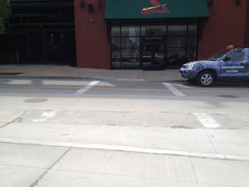 The newly  poured sidewalk & curb along Clark ignores crosswalks & ramps to reach Busch Stadium 