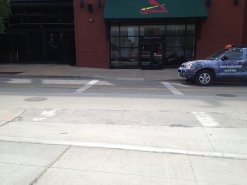 The newly poured sidewalk & curb along Clark ignores crosswalks & ramps to reach Busch Stadium