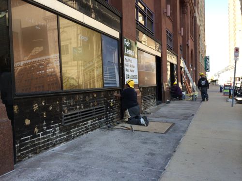 Workers demolishing the storefronts facing 9th Street