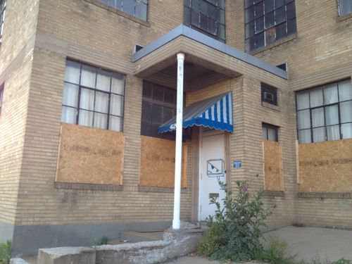 The industrial building that was razed filled the site, including being built up to the Clayton Ave sidewalk