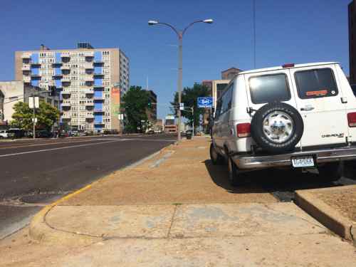 Van parked part way on the  Olive sidewalk at 9:40am on a Tuesday morning 