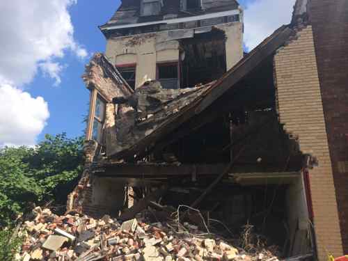 At 4035 the later commercial store front in from of a 19th century house has collapsed. 