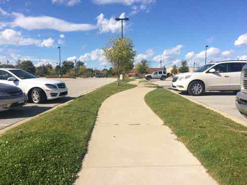 When we get further out we see it has changed to a sidewalk with regular parking spots on each side