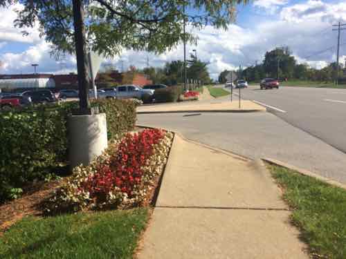 The first auto in/out on Woods Mill not only lacks a pedestrian entry but blocks a straight path. I got the contract info for a Town & Country employee who said Woods Mill Plaza is responsible, he'd contact them about this. 