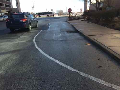 Again, a solid white line that curves back to the curb is a good clue this isn't for driving or parking. The text is faded and no sign is posted like the previous spot. The ramp is very visible,