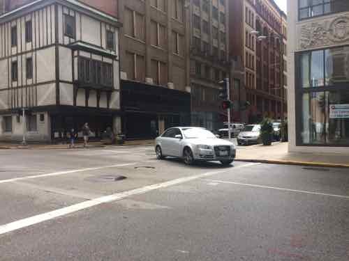 Driver makes a left onto 10th from Locust despite having a red light. 