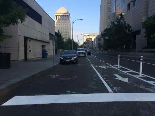 Looking West from 8th we see the bike lane goes around the delivery area. The white truck belongs to workers on the bike lane. 