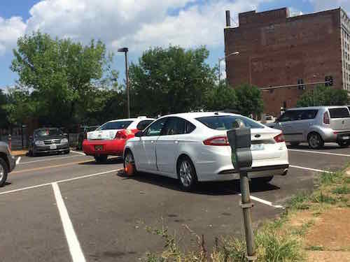 An orange boot was on the front wheel, the Kia had moved over one space and parked correctly. While I was in the area Parking Enforcement came by and removed the boot, the waiting owner then drove off. . 