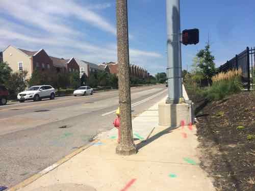 I'm at the ramp to cross Chouteau going South, the pedestrian button is on the back side of the silver pole! The visible button the side of the pole to cross Tucker heading East.