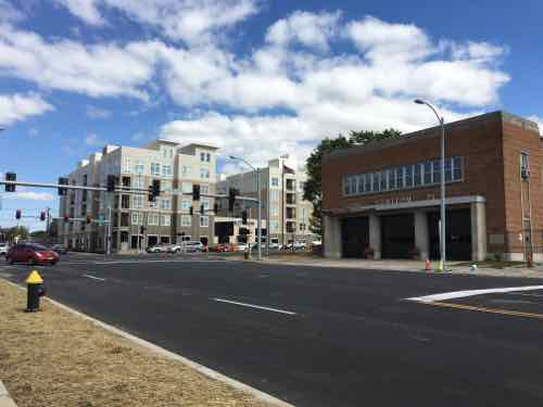 Two other corners contain urban buildings a historic firehouse and a new apartment complex built around a parking garage 