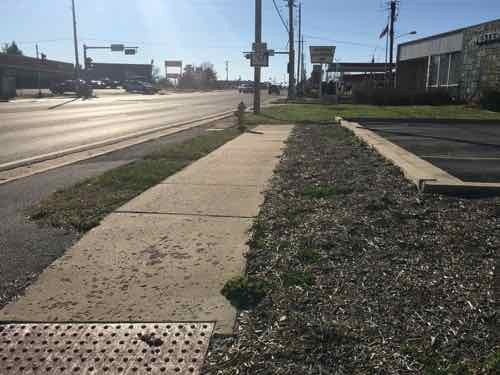 Looking South we have the same situation. A private sidewalk not usable by those who need it. Decoration adding to water runoff issues. 