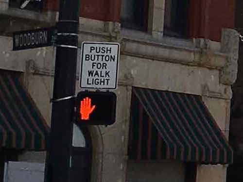 The sign above the pedestrian signal lets pedestrians know this signal requires activation