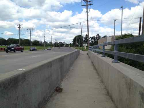 In 2012 the sidewalk on the bridge over the MetroLink light rail tracks was a narrow tunnel