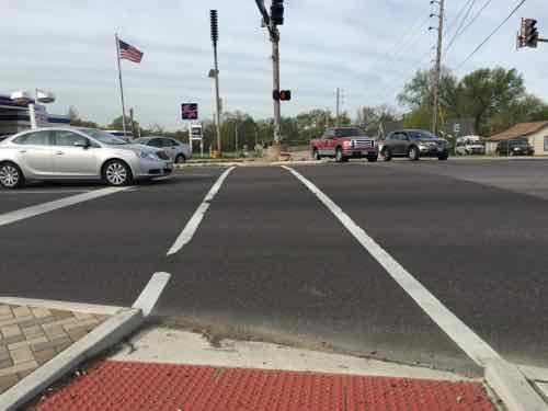 At new curb ramp looking from the NE corner South across Natural Bridge