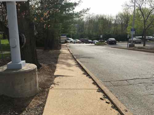 The sidewalk isn't wide enough for one person, has tilted. This was built in 1993 -- was designed to meet the bare minimum 