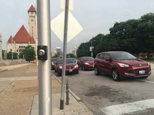 This view shows cars waiting next to a line of cars parked on the street 