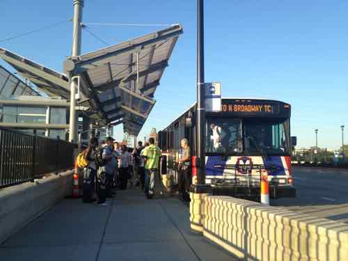 #70 MetroBus riders at the Grand MetroLink station, August 2012. Dislodge Tower can be seen in the distance  